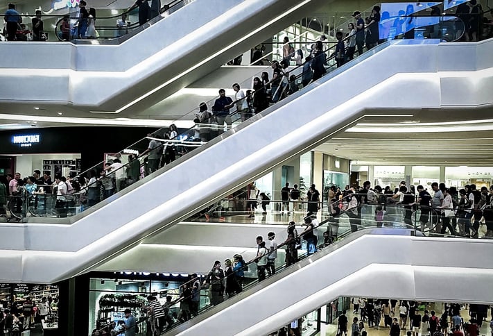 Shopping mall with crowds on escalators