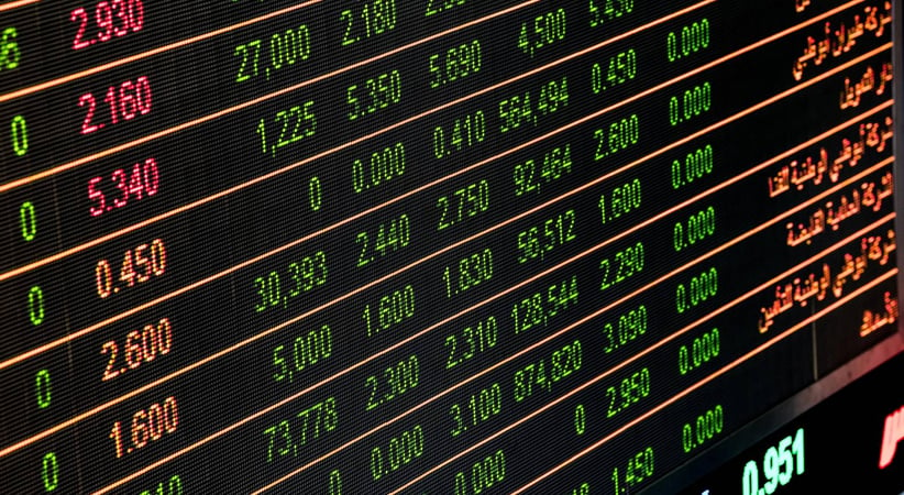 A digital stock ticker, with glowing green rows of numbers on a black background separated by orange divider lines.